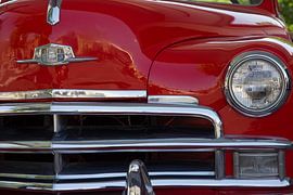 Hood and grill of a red classic car .