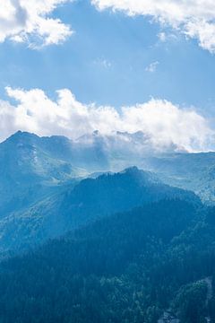 Ochtendlicht in de franse alpen. Zacht blauwe lagen van mist en wolken.