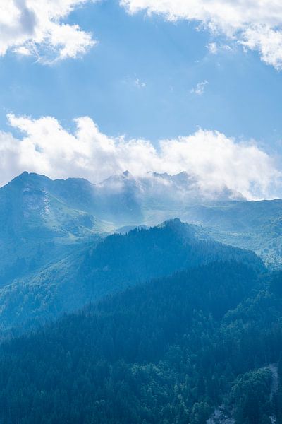 Morning light in the French alps. Soft blue layers of mist and clouds. by Christa Stroo photography