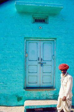 Indiase man passeert een huis. van Dick Termond