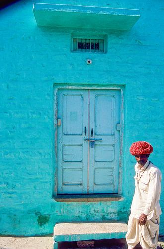 Indian man passes a house.