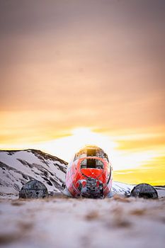 DC-3 vliegtuigwrak in besneeuwd landschap bij zonsondergang, Eyvindarholt, IJsland