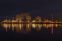 Blast furnaces Tata Steel IJmuiden at night with reflection in water