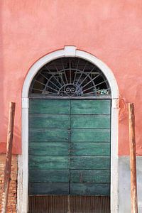 Salmon pink wall with green wooden doors in Venice