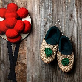 old Bollen hat with straw shoes in front of wooden wall by Jürgen Wiesler