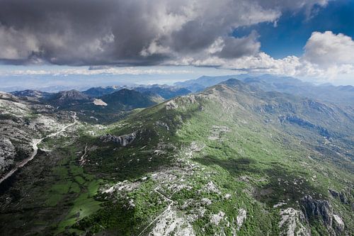 landscape below (aerial photo from a paraglider) with green mountains, severe with clouds. Montenegr