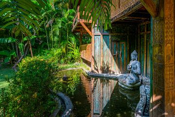 Buddha-Statue in einem Teich vor einem Haus von Rene Siebring