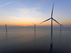 Windturbinen in einem Offshore-Windpark bei Sonnenuntergang