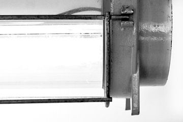 Foto van een detail van een oude scheepslamp in zwart wit. van Therese Brals