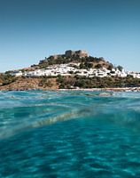 Wit dorp Lindos en kristalheldere zee in Griekenland Rhodos