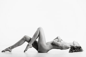 Nackte Frau mit einem schönen Körper auf dem Boden liegend. von Retinas Fotografie