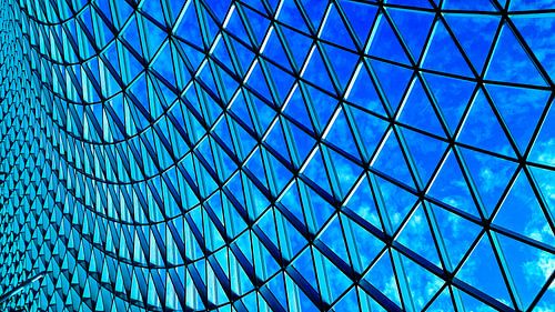 Modern koepeldak van staal-glas tegen blauwe lucht