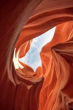 Oranje en bruine rotswand met doorkijk naar lucht