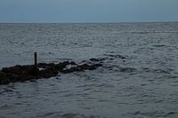 Eenzame paal in de golven