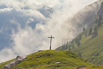 Croix dans un paysage alpin brumeux