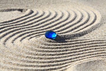 Sporen in het zand met blauwe steen van Karina Baumgart