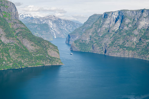 Deep blue Norwegian fjord between steep mountain walls