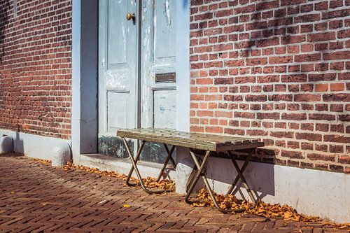 Houten bank voor oude deur