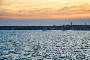 Sonnenuntergang über dem Meer mit Bootsspur und Silhouette am Horizont von Martin Köbsch