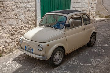 Oude beige Fiat 500 in binennstad van Ostuni, Italië
