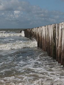 Wellenbrecher brechen die Wellen im Sonnenschein am Strand von Cadzand, Zeeland von Marjolijn van den Berg