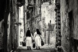 Italiaanse nonnetjes in een pittoresk straatje in Zuid Italië