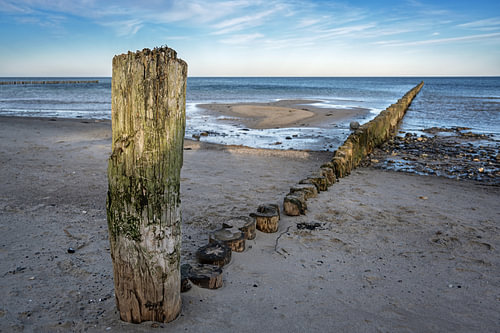 Verwitterte Holzbuhnen am Strand der Ostsee in Norddeutschland, touristische Erholungslandschaft, Ko