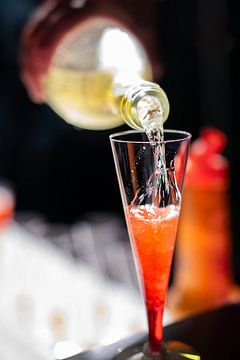 Cocktail rouge au champagne sur un bar.