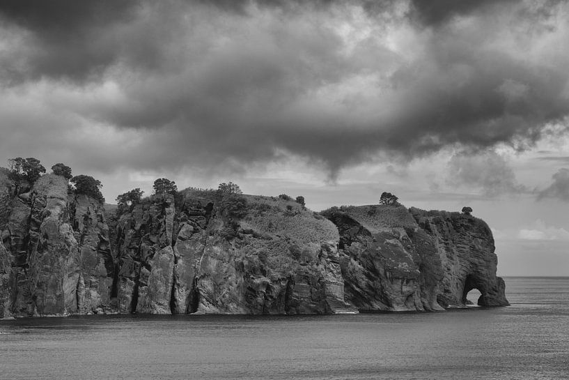 Felsenküste mit bedrohlichen Wolken von Bert Bouwmeester
