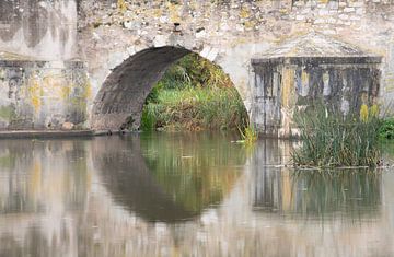 Een stenen brug weerspiegeld in het water