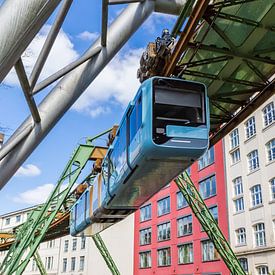 Hover train glides past historic buildings in Wuppertal by Marc Venema