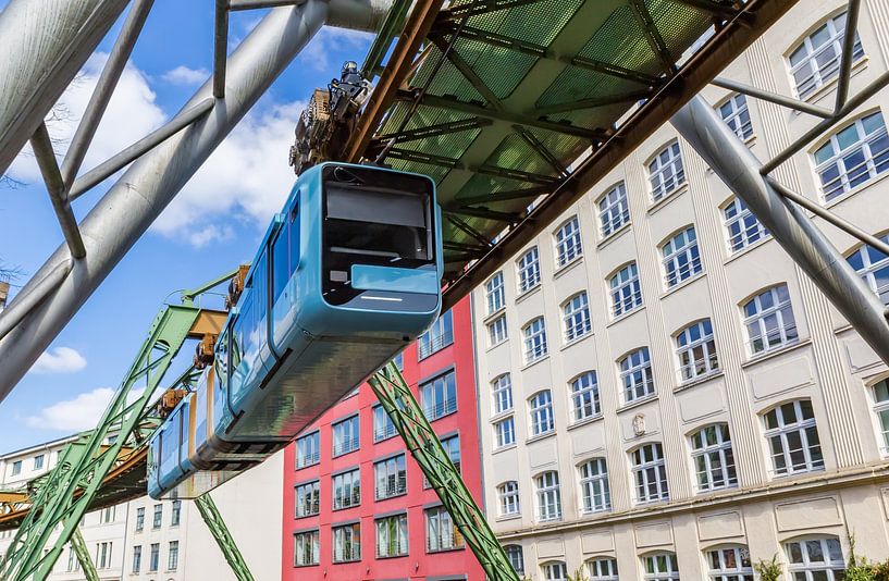 Hover train glides past historic buildings in Wuppertal by Marc Venema