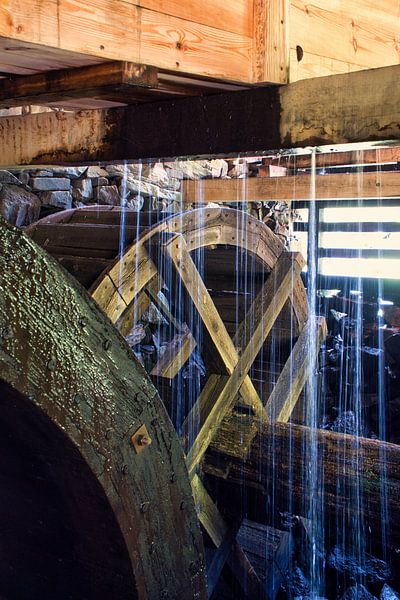 Altes hölzernes Wasserrad, das von fallendem Wasser bespritzt wird. Bild von einer Wassermühle in Schweden von Martin Köbsch