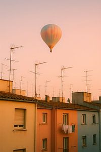 Heißluftballon über pastellfarbenen Häusern - weicher Abendhimmel mit warmen Farben