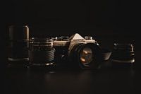 Olympus OM-2n met lenzen tegen een zwarte achtergrond