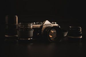 Olympus OM-2n met lenzen tegen een zwarte achtergrond