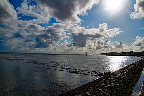 wolkenvelden belicht over watermassa