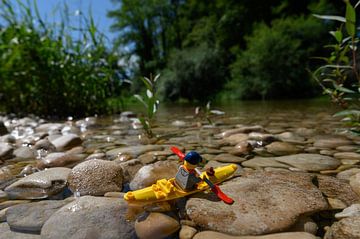 Lego poppetje in natuurlandschap met kano