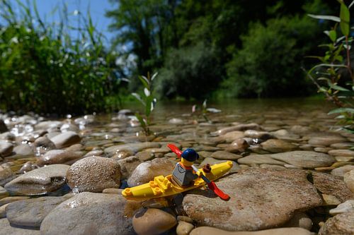 Lego puppet in natural landscape with canoe