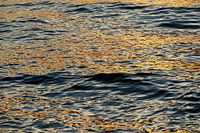 Die untergehende Sonne spiegelt sich im Wasser