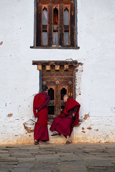 Monks peep through a window at a monastery in Bhutan by Teun Janssen