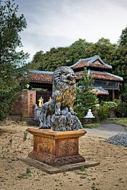 Carved lion watching over a sacred pagoda by Frank Photos