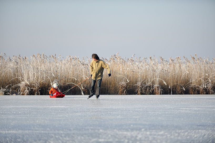 Eislaufender Vater mit Kind auf Schlitten von Merijn van der Vliet