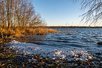 A beautiful lake with a snowy shore