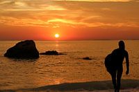 Surfing girl at sunset