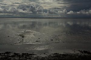 Wolkenluchten boven het drooggevallen Wad