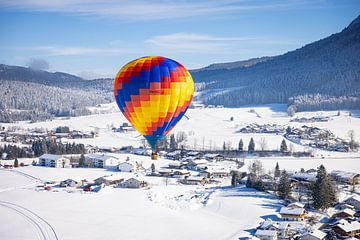 Een heteluchtballon boven een besneeuwd Inzell in Duitsland van Stefan Verkerk fotografie