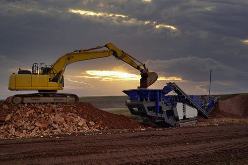 Steenbreker en graafmachine in actie