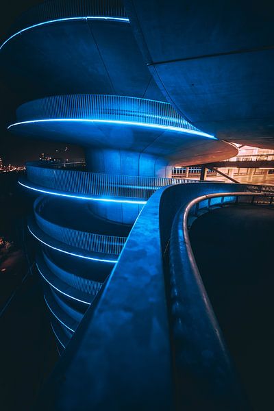 Illuminated parking garage in the dark by Martijn Van Weeghel