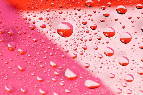 Waterdruppels op een glazen plaat met gekleurd papier